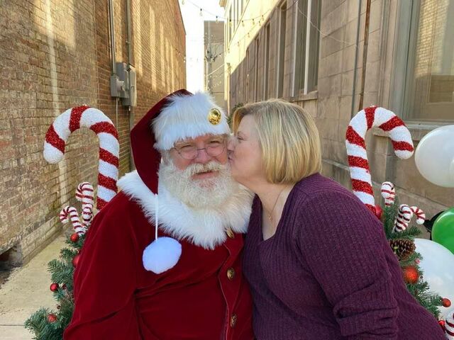 A woman giving Santa Sarge a kiss on the cheek