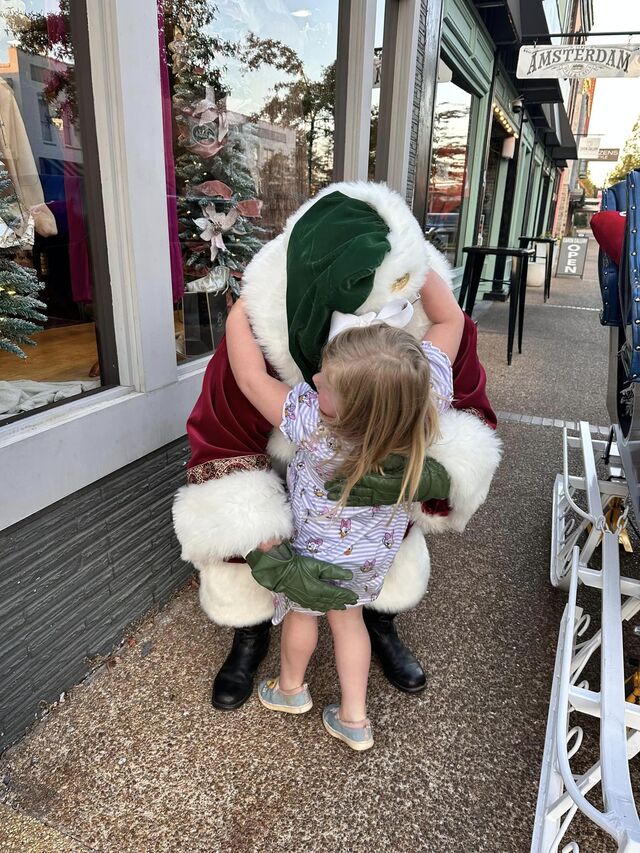 A little girl hugging Santa Sarge